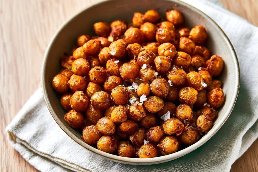 Pois chiches grillés et épicés servis dans un bol en céramique posé sur une serviette en lin
