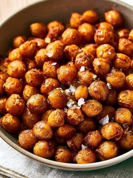 Pois chiches grillés et épicés servis dans un bol en céramique posé sur une serviette en lin
